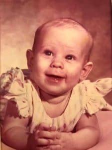 a little girl holding a baby